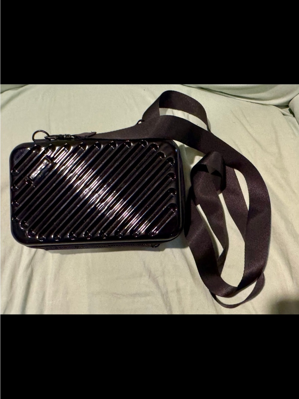 Black hard shell crossbody bag with adjustable strap